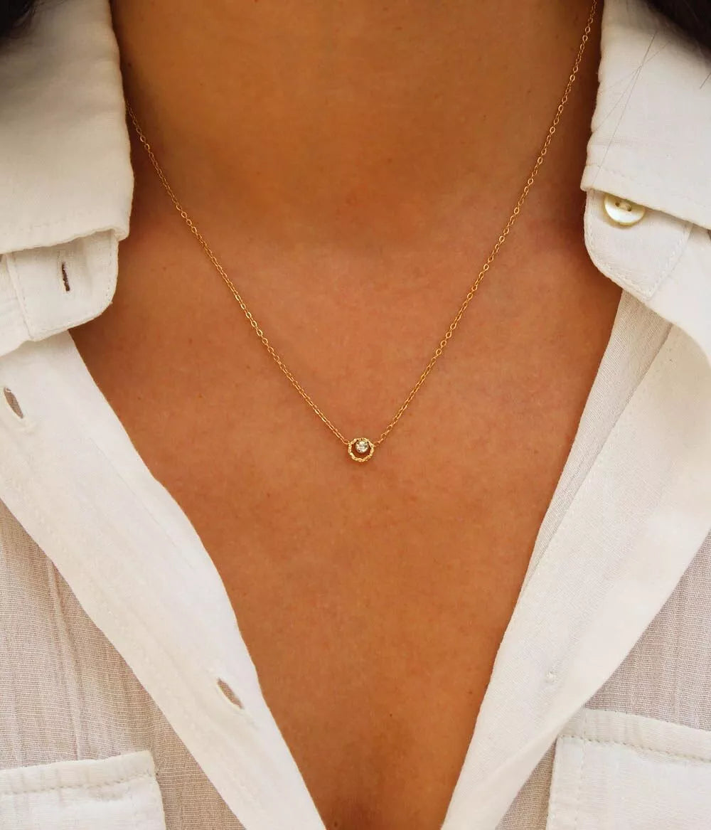 collier or strass posé sur buste femme maille forçat avec chemisier blanc