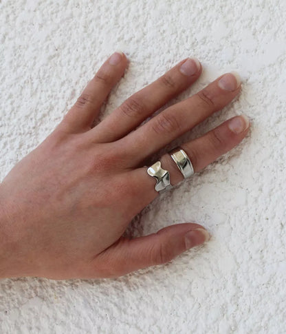 Bague argentée fine Pula sur main présentée avec une autre bague vue de dessus