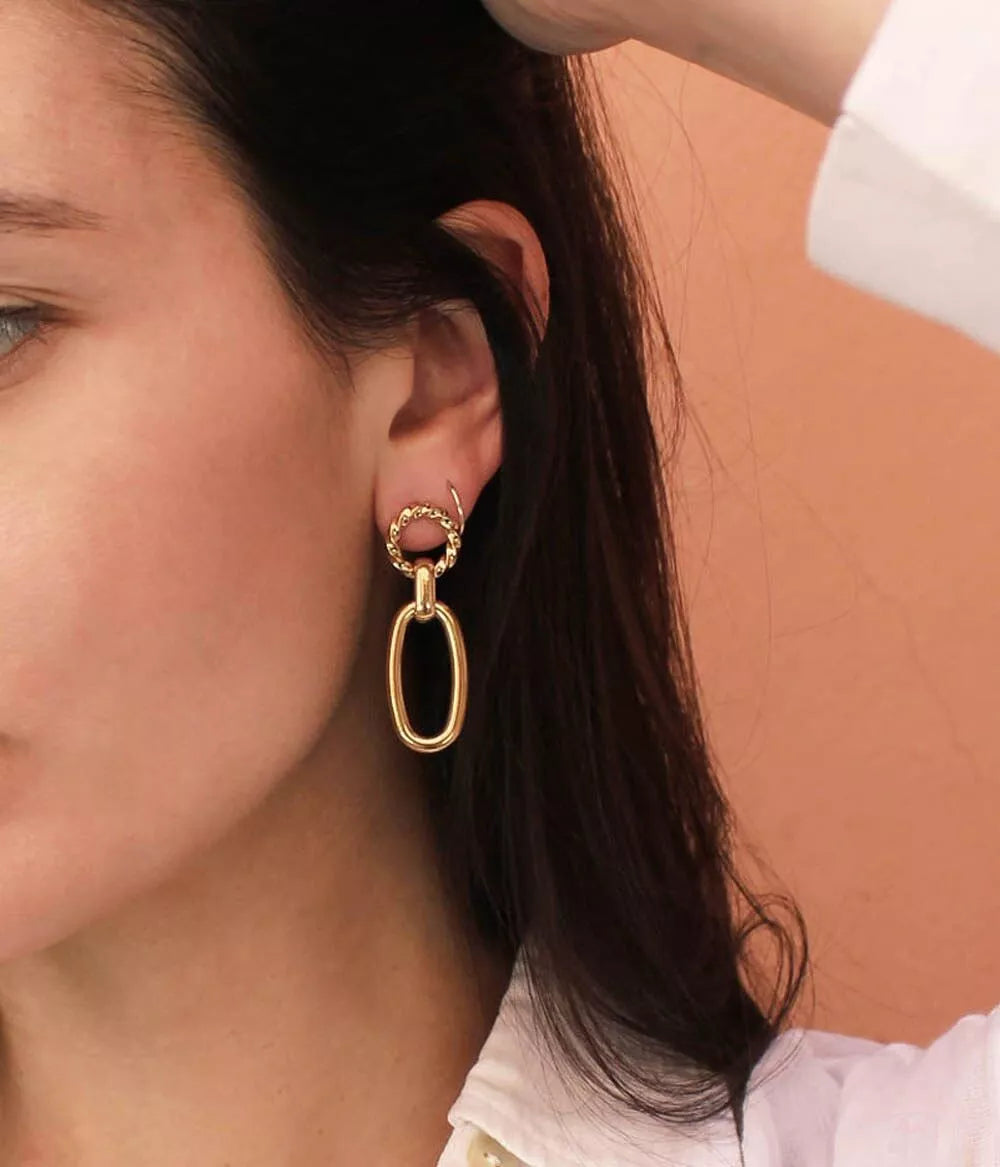 boucles d'oreilles à pendants cassia dorées sur oreille femme qui relève ses cheveux
