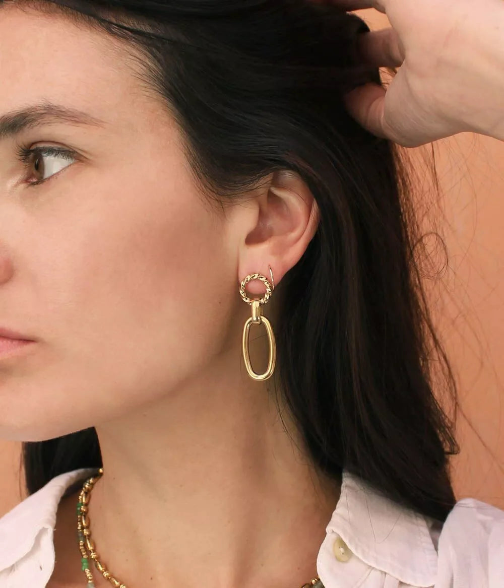 boucles d'oreilles à pendants cassia dorées sur oreille femme qui relève ses cheveux de face 