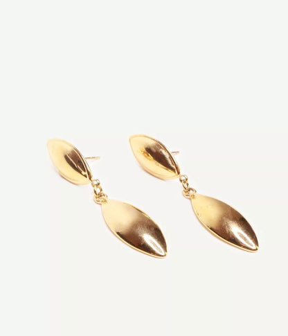 boucles à pendants forme de gouttes dorées à puce penchées sur la gauche sur fond blanc
