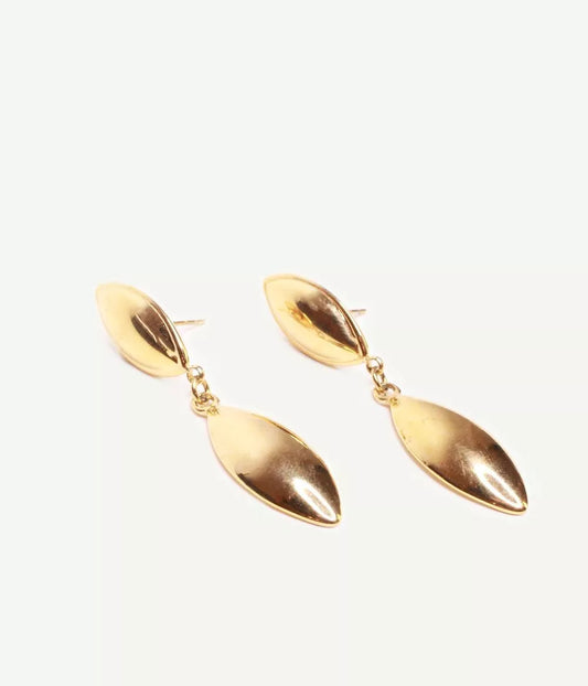 boucles à pendants forme de gouttes dorées à puce penchées sur la gauche sur fond blanc