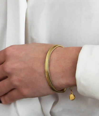 bracelet simone orporté sur poignet femme avec veste blanche