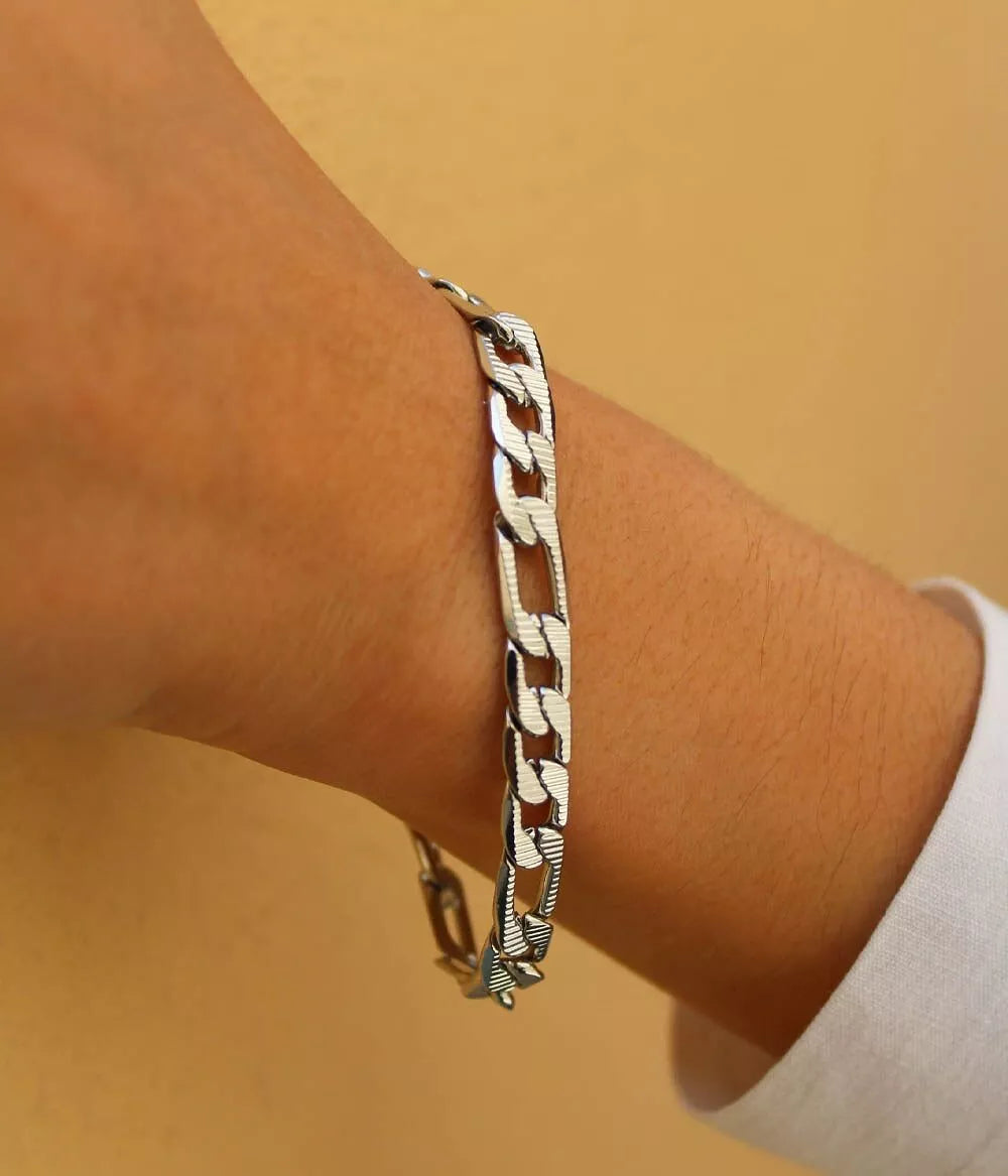 bracelet argenté maille figaro sur poignet femme 