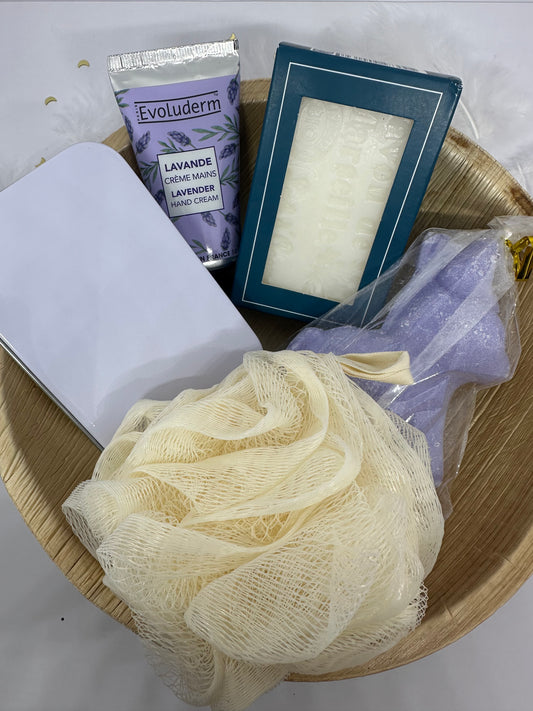 coffret cadeau avec plateau en feuille d'areca, une eponge de bain écrue, une boite savon métallique blanche, une crême pour les mains lavande evoluderm, un savon au lait d'anesse dans son emballage en carton bleu et un savon ane lavande dans son emballage transparent