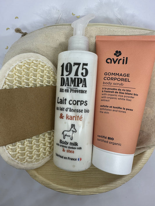 coffret avec plateau a la feuille d'areca, une éponge exfolliante écru en coton, un lait corps anesse et karité blanc, un gommage orange avril pour le corps et une trousse écru sur fond blanc avec paillettes dorées et plumes blanches