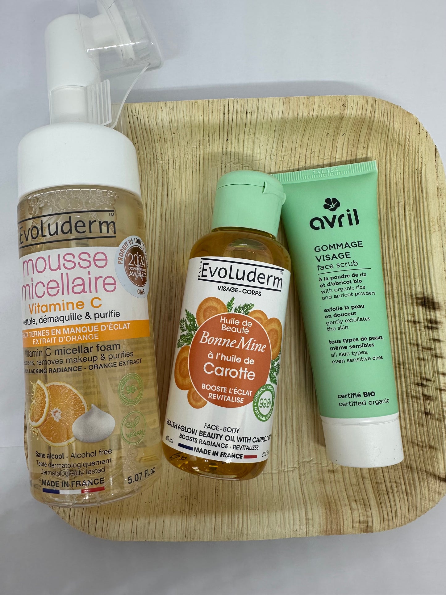 Coffret Teint Radieux avec mousse micellaire Evoluderm, gommage visage Avril et huile bonne mine à la carotte Evoluderm sur plateau en feuille d'Areca - routine éclat