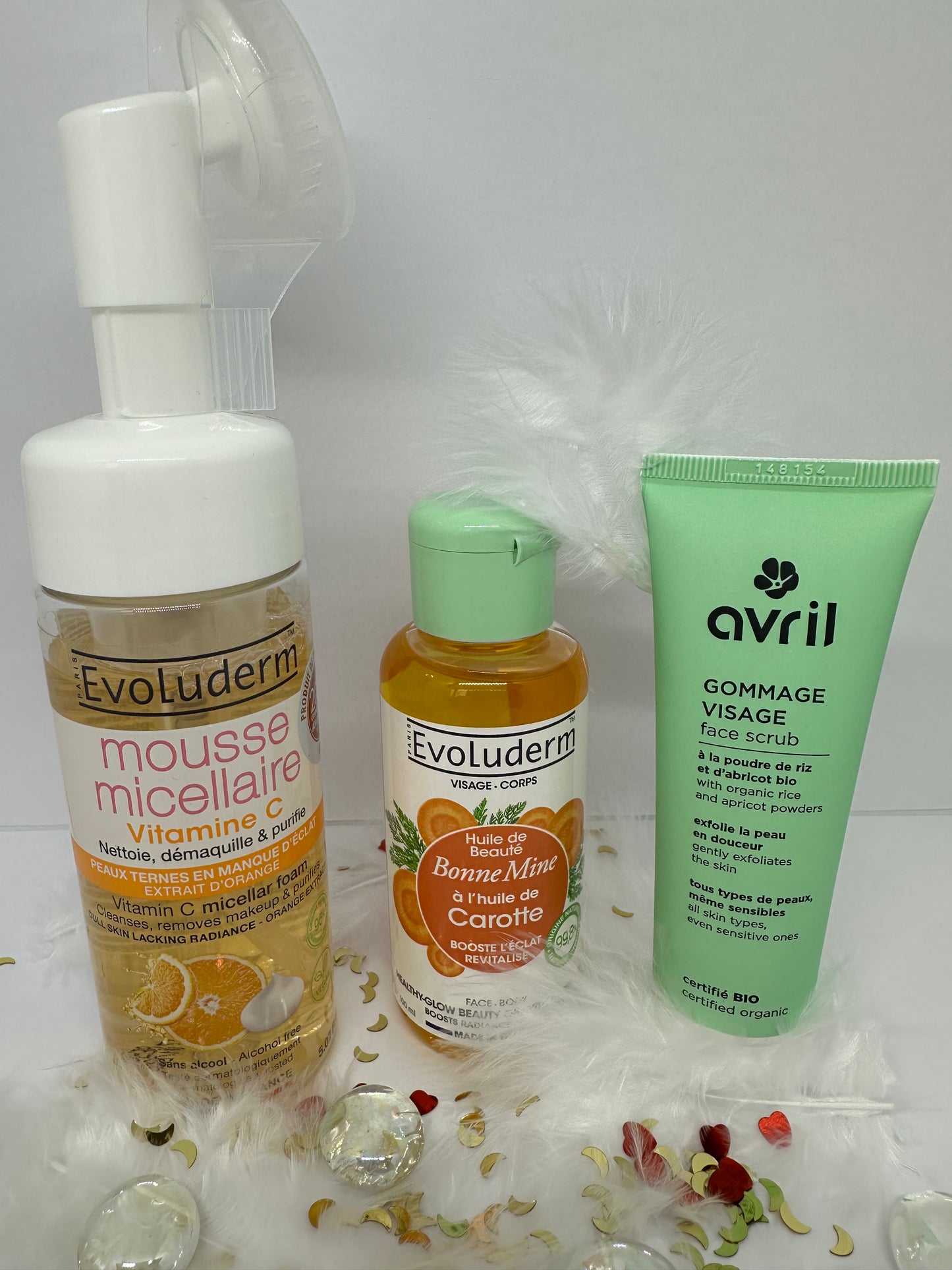 Trio du coffret Teint Radieux avec mousse micellaire et huile bonne mine à la carotte Evoluderm, et gommage visage Avril sur décor blanc - routine éclat