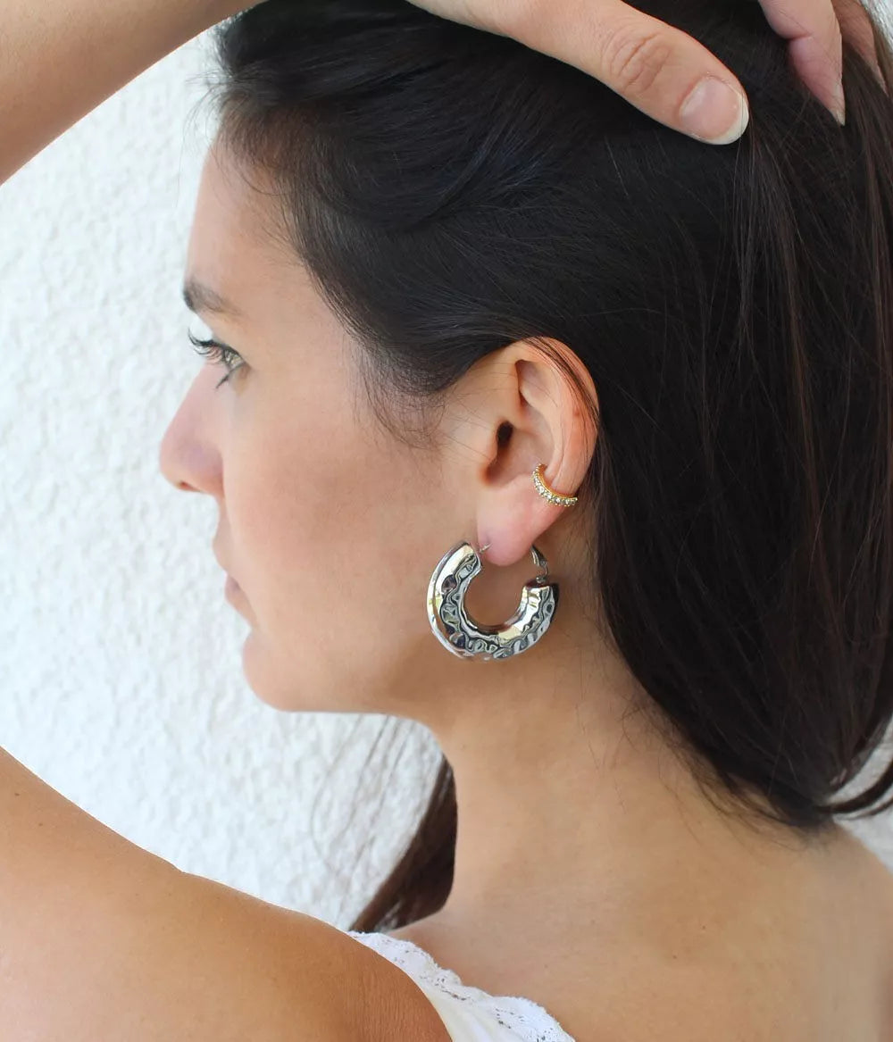 boucles créoles argentées sassari sur femme brune de profile qui lève ses cheveux avec sa main