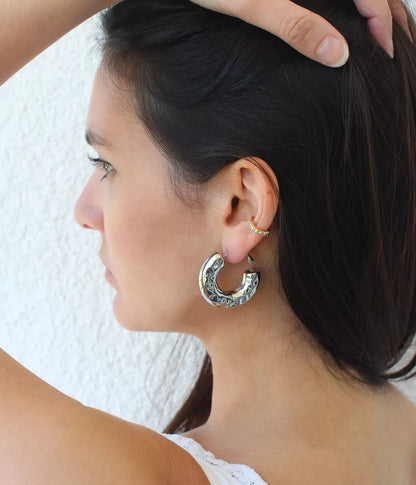 boucles créoles argentées sassari sur femme brune de profile qui lève ses cheveux avec sa main