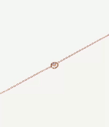 collier or strass dans petit cercle posé sur fond blanc maille forçat