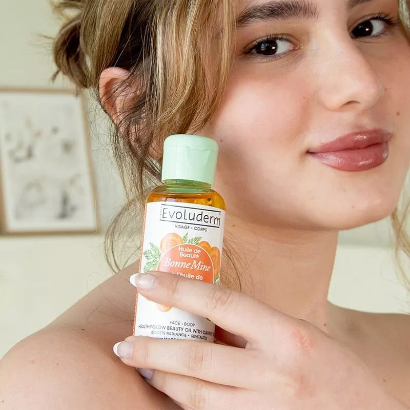 jeune femme tenant l'huile bonne mine evoluderm près de son visage - mise en avant produit