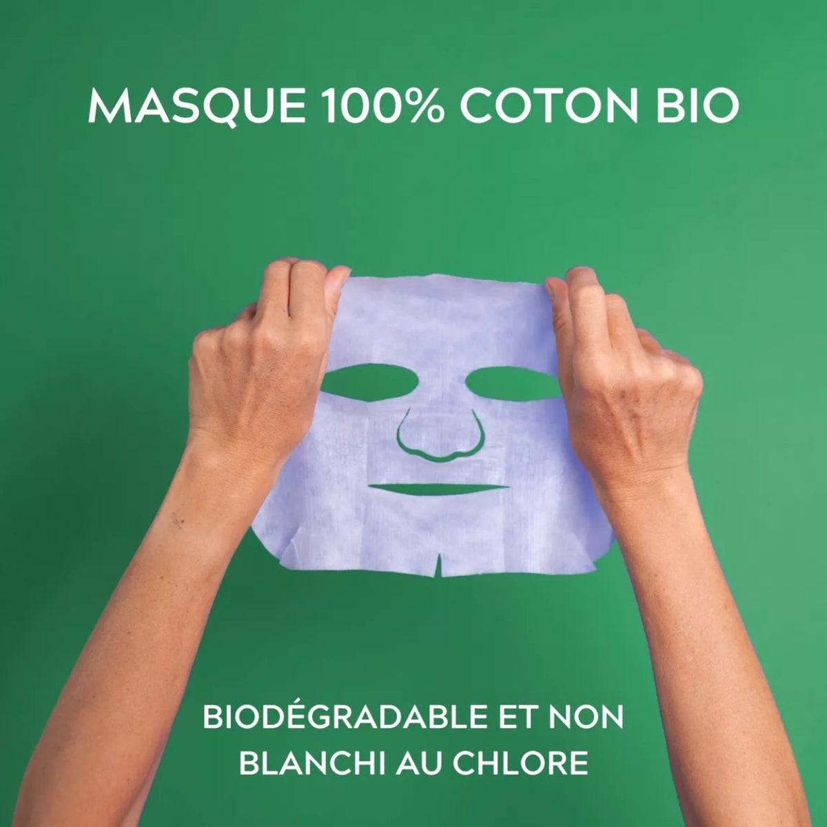Masque visage en coton bio, biodégradable, non blanchi au chlore, tenu à deux mains sur fond vert

