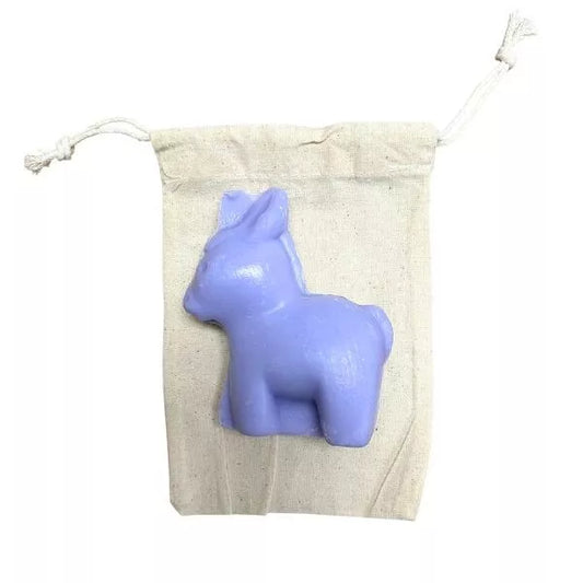 Savon en forme de petit âne violet, parfum lavande, posé sur un pochon en coton naturel, fabrication artisanale française.