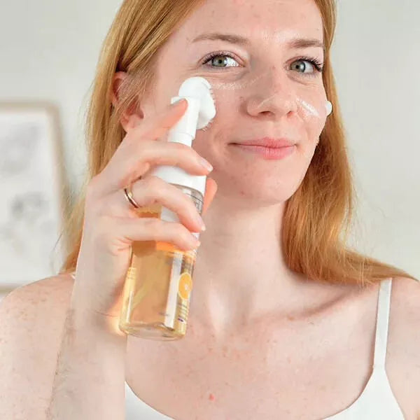 femme applicant la mousse micellaire vitamine c sur son visage avec la brosse