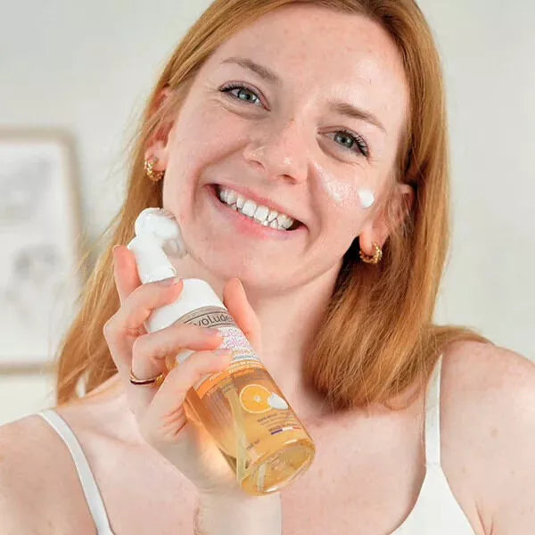 femme  tenant flacon de mousse micellaire vitamine c evoluderm sur son visage