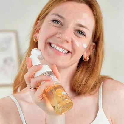 femme  tenant flacon de mousse micellaire vitamine c evoluderm sur son visage