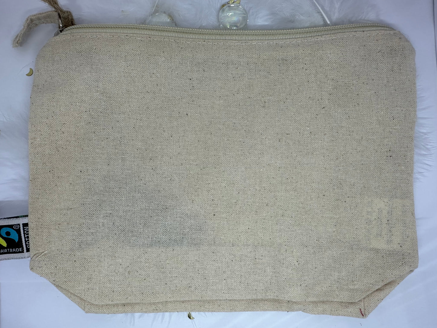 trousse écrue à zip en coton sur fond blanc avec billes transparente, plumes blanches et paillettes dorées